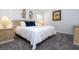 Bedroom with king bed featuring blue accent pillows, art, and matching nightstands with lamps at 6402 Parc Corniche Dr # 5304, Orlando, FL 32821