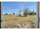 Spacious backyard with large grassy areas, shrubs, and distant trees, seen from the home at 7 Garvey Ln, Frostproof, FL 33843