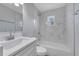 Modern bathroom featuring a tub with marble tile surround, a sleek vanity, and natural light from a window at 7 Garvey Ln, Frostproof, FL 33843