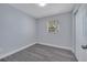 Cozy bedroom featuring a window with natural light and modern gray floors, creating a serene space at 7 Garvey Ln, Frostproof, FL 33843