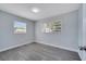 Bright bedroom featuring two windows with natural light and modern gray floors, creating an airy space at 7 Garvey Ln, Frostproof, FL 33843