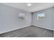 Bedroom featuring two windows, fresh paint, and modern gray floors, creating a comfortable space at 7 Garvey Ln, Frostproof, FL 33843