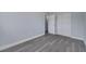 Bright bedroom featuring wood-look floors, neutral paint, and a double-door closet at 7 Garvey Ln, Frostproof, FL 33843
