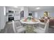 Open-concept dining area features modern white cabinets, stainless steel appliances, and a stylish dining set at 7 Garvey Ln, Frostproof, FL 33843