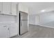 Kitchen area showcases stainless refrigerator, white cabinets and gray flooring at 7 Garvey Ln, Frostproof, FL 33843