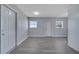 Bright living room with gray floors, white doors, and two windows at 7 Garvey Ln, Frostproof, FL 33843