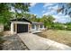 Charming single-story home featuring a bright blue door, manicured landscaping, and a freshly painted exterior at 741 Orange Ave, Longwood, FL 32750