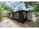 Dark siding and white trim accent the home's rear exterior with window and door to backyard and patio at 741 Orange Ave, Longwood, FL 32750