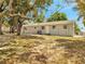 Image of the backyard of the property with mature trees and lush grass at 75 Garrison Ln, Frostproof, FL 33843