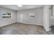 Spacious bedroom features neutral paint, wood flooring, and natural light from two windows at 75 Garrison Ln, Frostproof, FL 33843