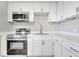 Well-equipped kitchen with stainless steel appliances, stylish white cabinets, and modern fixtures at 75 Garrison Ln, Frostproof, FL 33843