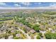 An aerial view shows the house roof in relation to the neighborhood landscape with lush trees and foliage at 902 Hire Cir, Ocoee, FL 34761