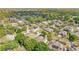 An aerial view highlights the community with tree-lined streets and a nearby lake and surrounding greenery at 902 Hire Cir, Ocoee, FL 34761