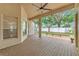 Covered back porch with wood flooring and ceiling fan, overlooking a fenced yard with mature trees at 902 Hire Cir, Ocoee, FL 34761