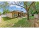 A view of the home's backyard featuring a covered patio, lush green grass, and mature trees at 902 Hire Cir, Ocoee, FL 34761