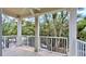 Cozy covered balcony with white railings and columns, overlooking a tree-lined street, perfect for relaxation at 921 Begonia Rd # 302, Celebration, FL 34747