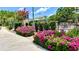 Manicured landscaping with vibrant pink flowers near the walkway to community pool and amenity area at 921 Begonia Rd # 302, Celebration, FL 34747