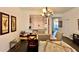 Open dining room with wood table, neutral chairs, chandelier, and view of the kitchen with white appliances at 921 Begonia Rd # 302, Celebration, FL 34747