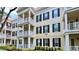 Beautiful condo building featuring private balconies, black window shutters, and lush landscaping at 921 Begonia Rd # 302, Celebration, FL 34747
