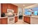 Kitchen area features stainless appliances, wood cabinetry, tile flooring, and an open archway to the living area at 921 Begonia Rd # 302, Celebration, FL 34747