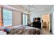 Main bedroom with natural light, ceiling fan, wood floors, and space for a desk and lounge area at 921 Begonia Rd # 302, Celebration, FL 34747