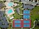 A clear aerial of community amenities including pools, tennis and basketball courts surrounded by lush green spaces at 9544 Mere Pkwy, Orlando, FL 32832