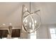 Modern chandelier with silver finish above the kitchen dining area and dark cabinetry at 9544 Mere Pkwy, Orlando, FL 32832