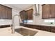 Modern kitchen with dark wood cabinets, stainless steel appliances, and a stylish island with a sink at 9544 Mere Pkwy, Orlando, FL 32832