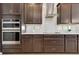 Close-up of kitchen details showcasing dark cabinets, quartz countertops, and stainless steel appliances at 9544 Mere Pkwy, Orlando, FL 32832