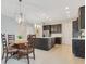 Open kitchen and dining area featuring stainless appliances, pendant lights, and dark cabinets at 9544 Mere Pkwy, Orlando, FL 32832