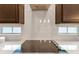 Elegant kitchen featuring white tile backsplash, dark wood cabinetry, and a sleek stovetop with modern ventilation at 9544 Mere Pkwy, Orlando, FL 32832