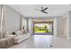 Bright living room with neutral tones, tile flooring, and seamless indoor-outdoor flow to the backyard patio at 9544 Mere Pkwy, Orlando, FL 32832
