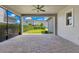 Covered outdoor patio with brick flooring, ceiling fan, and a view of the manicured backyard at 9544 Mere Pkwy, Orlando, FL 32832