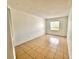 A bright bedroom boasts tiled floors, a neutral palette, and a window with natural light at 9903 Turf Way # 4, Orlando, FL 32837
