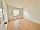 A cozy bedroom features tiled floors, a light-filled window, and neutral decor at 9903 Turf Way # 4, Orlando, FL 32837