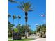 Community entrance featuring lush tropical landscaping, community signage, and a view of the American flag at 9903 Turf Way # 4, Orlando, FL 32837