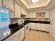 Well-lit kitchen features white appliances and cabinets, alongside a black countertop at 9903 Turf Way # 4, Orlando, FL 32837