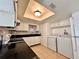 Bright kitchen features white cabinets, black countertops, and laundry appliances at 9903 Turf Way # 4, Orlando, FL 32837