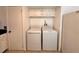Bright laundry area with white washer and dryer adjacent to kitchen at 9903 Turf Way # 4, Orlando, FL 32837