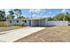 Charming single-story home featuring a well-manicured lawn, blue door, and a convenient carport at 994 Lormann Cir, Longwood, FL 32750