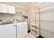 Laundry room with white washer and dryer units, as well as white metal rack at 994 Lormann Cir, Longwood, FL 32750