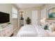 A staged main bedroom with luxury bed, accent cabinet, and interior door to bathroom at 994 Lormann Cir, Longwood, FL 32750