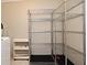 A view of metal storage shelves next to a white shelf near the washing machine at 994 Lormann Cir, Longwood, FL 32750