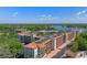 Scenic aerial view of the condominium complex boasting a lush landscape and lake views on a bright, sunny day at 100 S Interlachen Ave # 410F, Winter Park, FL 32789