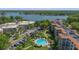 Aerial view of the community featuring lush landscaping, a pool, tennis courts, and lake views at 100 S Interlachen Ave # 410F, Winter Park, FL 32789