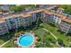 Aerial view showcasing the community pool, adjacent building, and surrounding landscape at 100 S Interlachen Ave # 410F, Winter Park, FL 32789