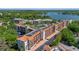 Aerial view showcasing residential buildings with terracotta roofs, lush landscaping, and parking at 100 S Interlachen Ave # 410F, Winter Park, FL 32789
