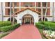 Welcoming building entrance with a terracotta walkway, lush landscaping, and classic architectural details at 100 S Interlachen Ave # 410F, Winter Park, FL 32789