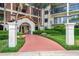 Inviting building entrance with a terracotta walkway, lush landscaping, and classic architectural details at 100 S Interlachen Ave # 410F, Winter Park, FL 32789