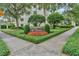 Beautifully landscaped community entrance to The Cloisters, featuring mature trees and colorful flower beds at 100 S Interlachen Ave # 410F, Winter Park, FL 32789